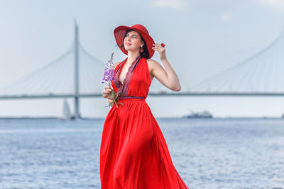 Young woman standing against sea