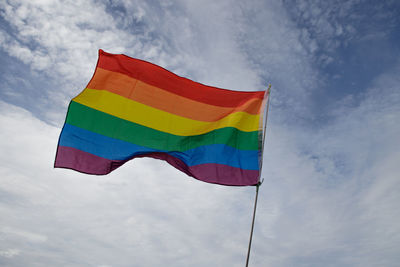 Low angle view of rainbow flag against sky