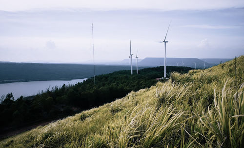 Wind turbines on land against sky