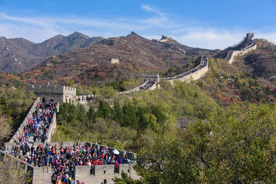 People on great wall of china against blue sky during sunny day