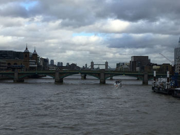 Bridge over river against cloudy sky