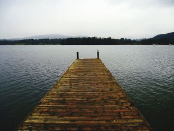 Empty jetty over lake windermere against clear sky