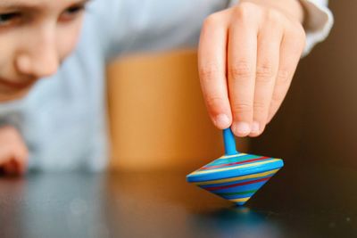 Cropped hand of a child spinning a wooden whirligig 