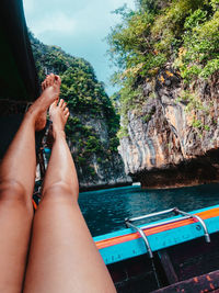 Low section of woman relaxing on boat in sea