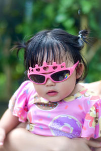 Portrait of young woman wearing sunglasses while standing outdoors