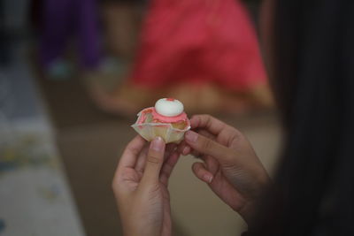 Close-up of hand holding cup cake