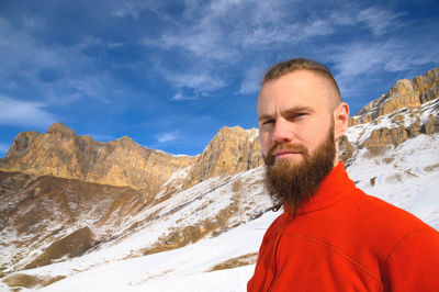 Portrait of man with snowcapped mountains against sky