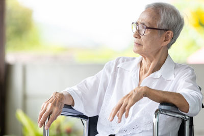 Midsection of man wearing hat sitting outdoors