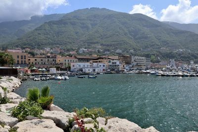 Scenic view of sea by townscape against sky