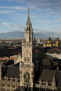 Buildings in city against cloudy sky