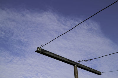 Low angle view of telephone pole against sky