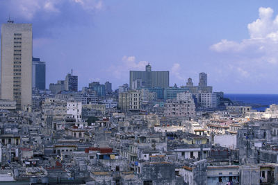 Buildings in city against cloudy sky