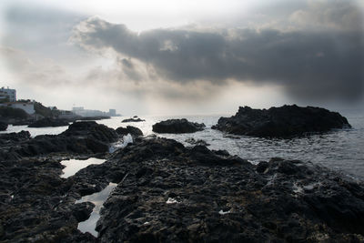 Rocks on beach against sky