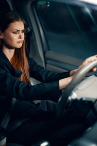 Sad young woman sitting in car