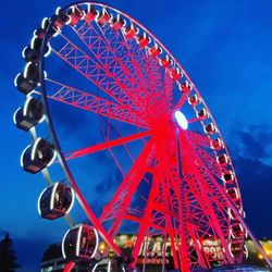 Low angle view of illuminated ferris wheel against sky