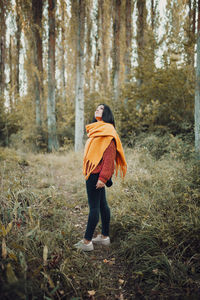 Woman standing on field in forest