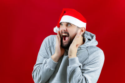 Man wearing hat against red background