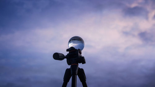 Low angle view of person photographing against sky