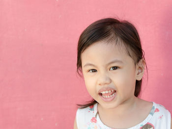 Dramatic portrait of 4 years old cute baby asian girl, little toddler child looking at camera.