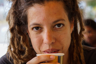 Close-up portrait of mid adult woman drinking coffee