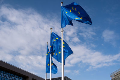 Low angle view of flags against blue sky