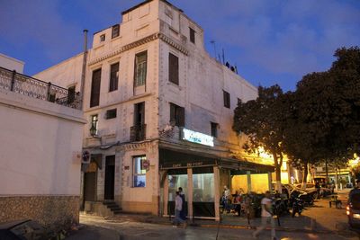 People on street against buildings in city