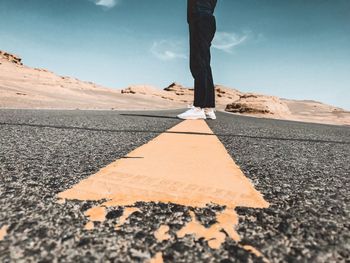 Low section of man skateboarding on road