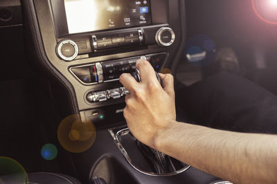 Cropped hand of man holding gearshift in car