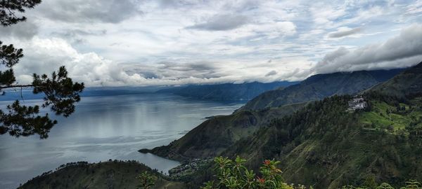 Scenic view of sea and mountains against sky