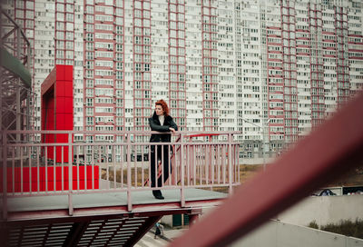 Rear view of woman standing against wall