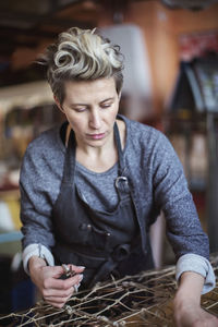 Female worker making chaise longue at workshop