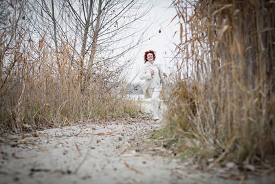 Pretty young woman in trendy white clothes poses in motion