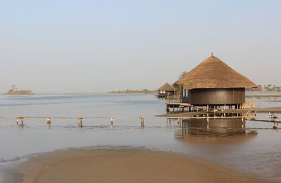 House on beach by sea against clear sky