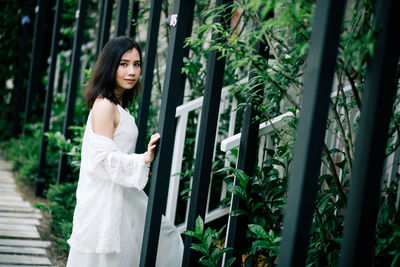 Side view portrait of woman standing by plants