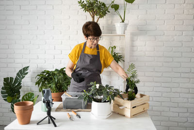 Young woman holding potted plant