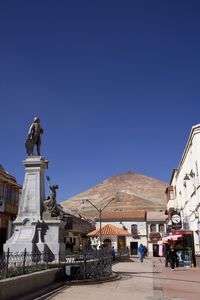 Low angle view of statue against clear blue sky