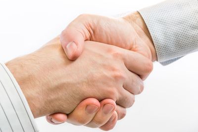 Close-up of man holding hands over white background