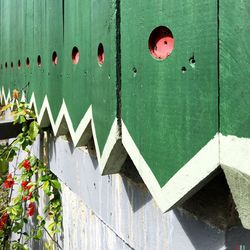 Green wooden fence above plants in yard