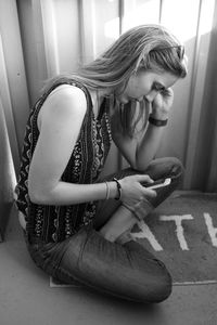 Woman sitting on the floor using mobile phone