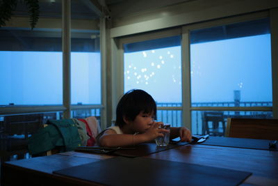 Portrait of boy sitting at table