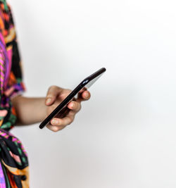 Midsection of woman using smart phone against white background