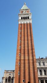 Low angle view of clock tower against clear blue sky