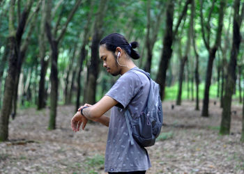 Side view of young man in forest