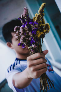 Portrait of woman holding purple flower