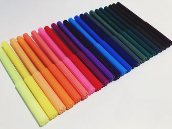 High angle view of multi colored pencils against white background