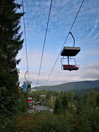 Low angle view of overhead cable car against sky