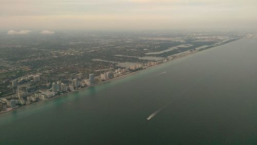 Aerial view of sea with cityscape in background