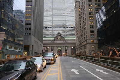 Traffic on road amidst buildings in city