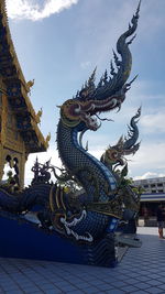 Low angle view of sculpture on building against sky