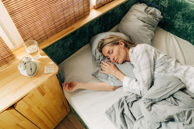 High angle view of woman lying on bed at home